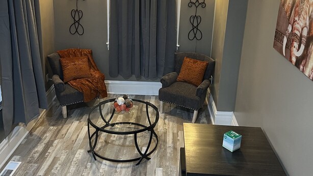 Un salon moderne avec deux fauteuils, une table basse et une table d’appoint.