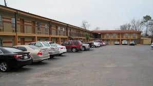 Un motel con múltiples espacios de estacionamiento y un edificio con balcones.