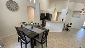 A modern kitchen with white cabinets, a built-in microwave, and a refrigerator. - Palm Tree Fairways (Haines City)