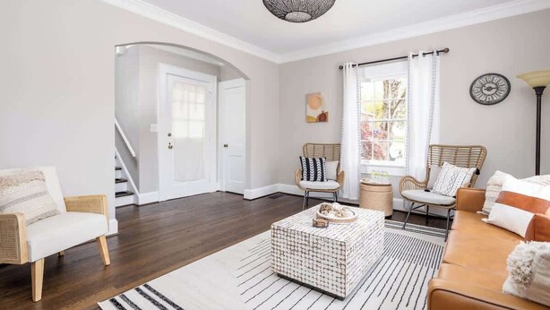 Una sala de estar moderna con una escalera, una mesa de centro y un sofá.