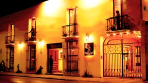 Un hotel con varios balcones, una puerta roja y un letrero que indica que es el Hotel Danibaaan.