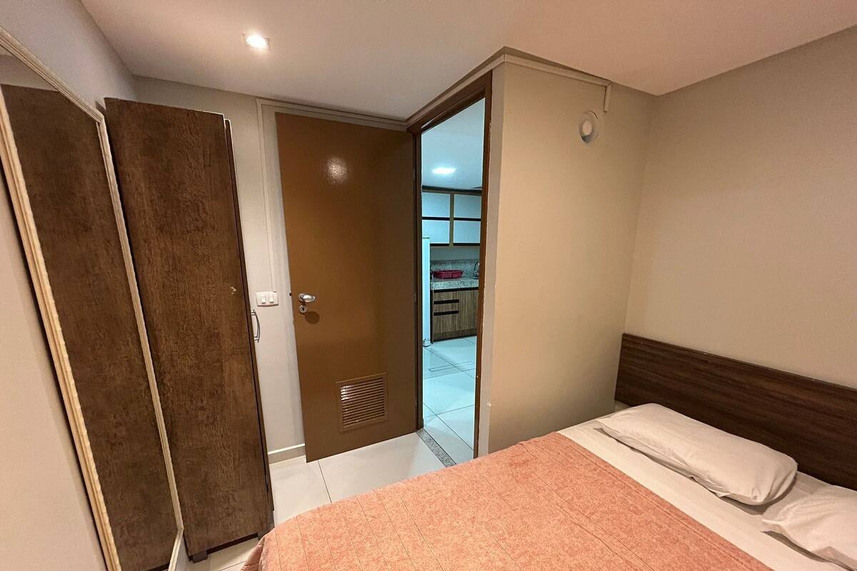 Un dormitorio con cama, un armario y una puerta que da a la cocina.