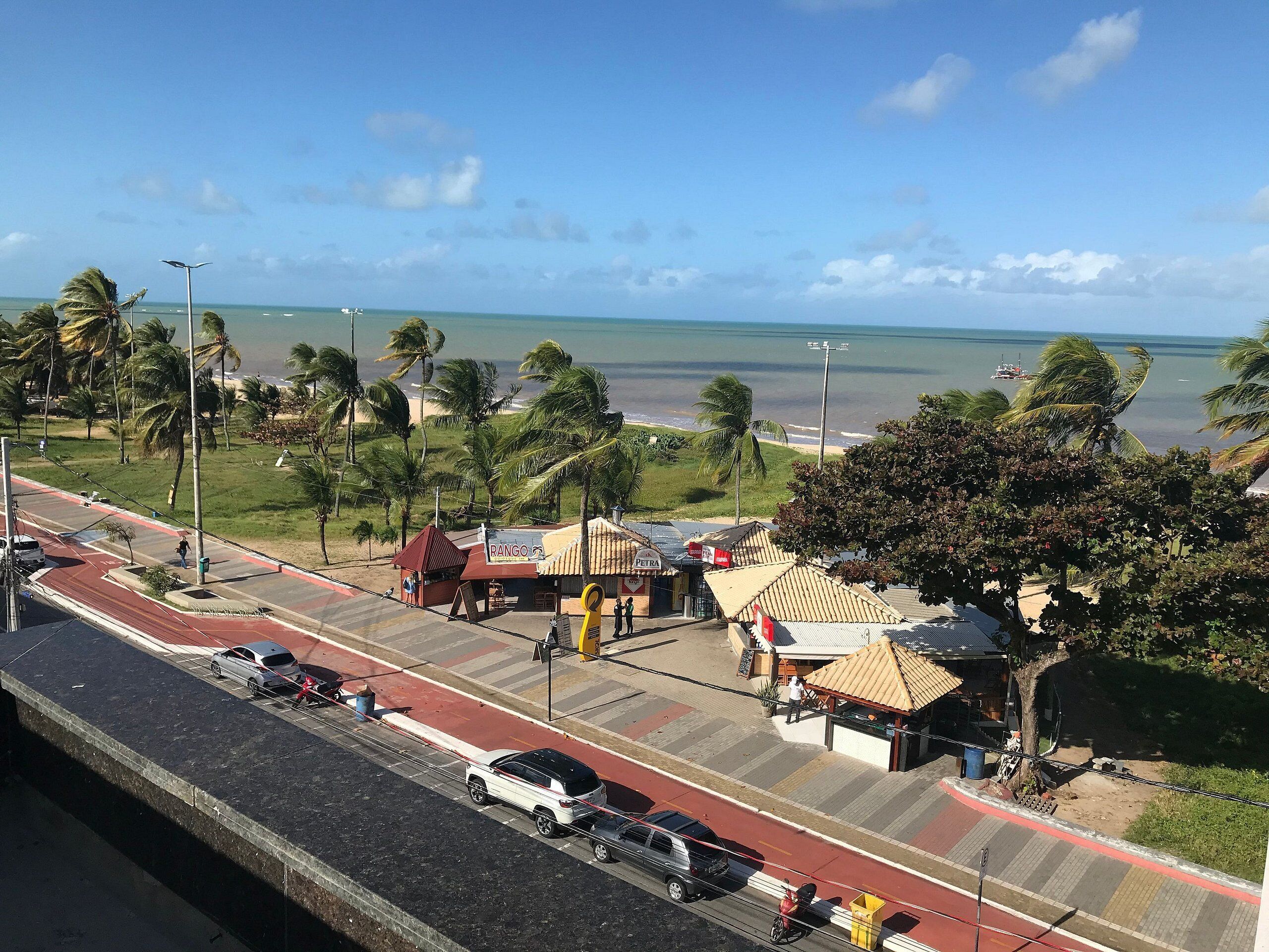 A coastal road with a pedestrian crossing, a small building labeled 'RANGO,' and a view of the ocean.