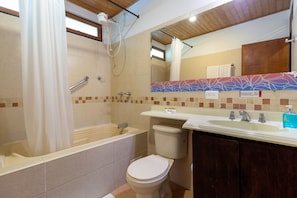 Een badkamer met een bad, toilet en wastafel.