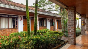 A covered outdoor area with a brick building, numbered 107, and a fire extinguisher mounted on the wall. - Hotel Campestre La Potra (Villavicencio)