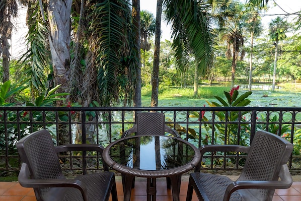 A round table with two chairs in a tropical garden setting.