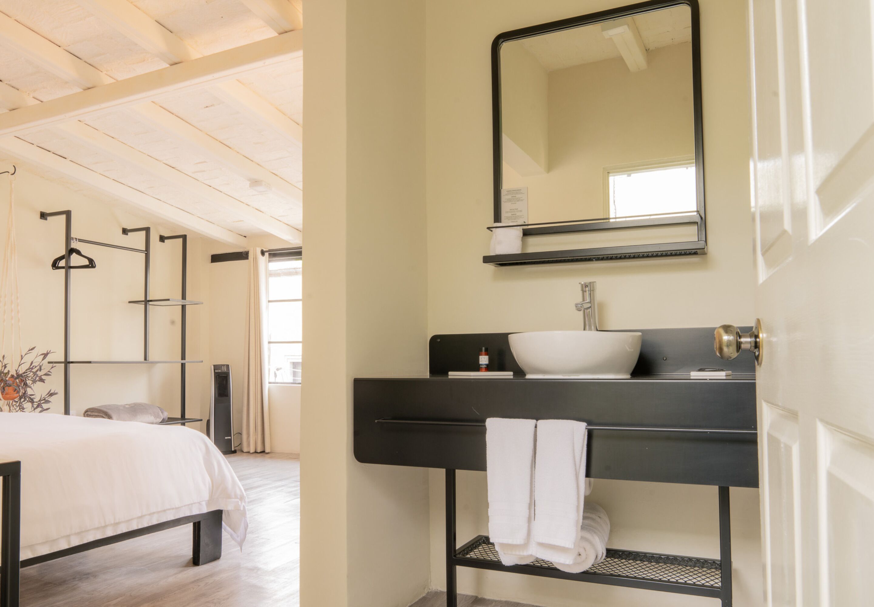 Une salle de bain moderne avec un meuble-lavabo noir, un lavabo blanc et un grand miroir.