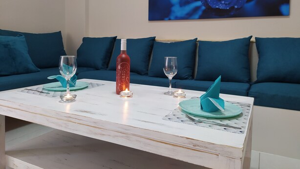 A dining table with two wine glasses, a bottle, and candles. - Modern Quiet Apartment in Rhodes center (Rhodes)