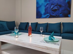 Een eettafel met twee wijnglazen, een fles en kaarsen.