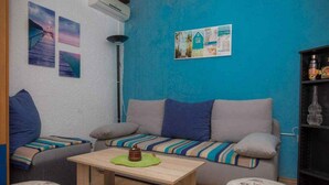 A cozy living room with a sofa, ottomans, a coffee table, and wall art.