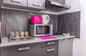 A kitchenette with a microwave, kettle, and coffee maker on the countertop. - Holiday apartment with air conditioning and roof terrace (Dramalj)