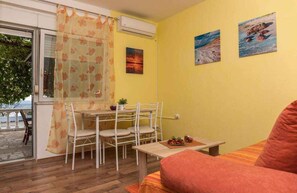 Una habitación con una mesa de comedor, sillas, un sofá y un ventanal con vistas.