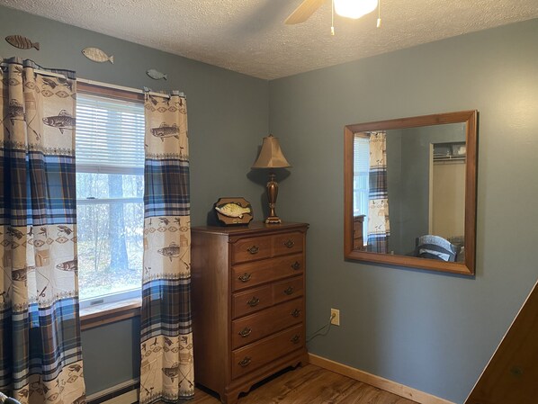 A room with a wooden dresser, a mirror, and a window with curtains. - Rickett’s Hidden Treasure- Sullivan County (Lopez)
