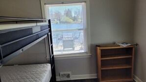 A bedroom with a bunk bed, a window with blinds, a wooden shelf, and a vent. - Lake Front home with with pontoon boat available for rent (Marcellus)
