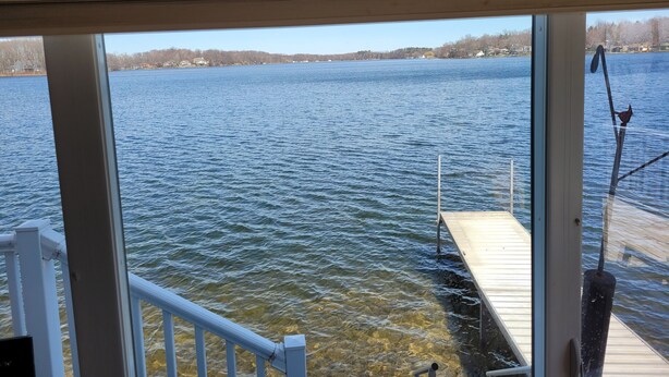 A view of a lake from a wooden cabin with a dock extending into the water. - Lake Front home with with pontoon boat available for rent (Marcellus)