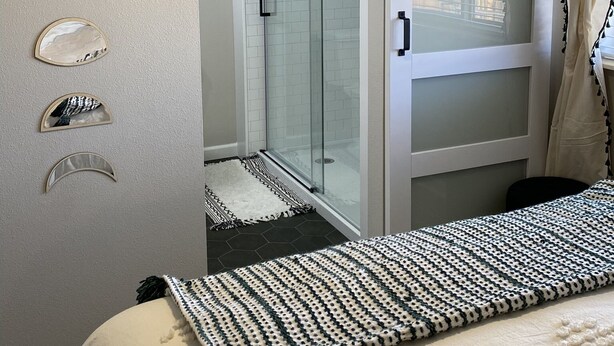 A bedroom with a bed, a glass shower enclosure, and a wardrobe with a sliding door. - Cozy BV Home w/ views: 1mi to Main St STR-111 (Buena Vista)