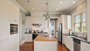 A kitchen with white cabinetry, a wooden island, stainless steel appliances, and a window with blinds. - ☀️Picturesque Views💥Game room👙Pool & Hot Tub (Brunswick)