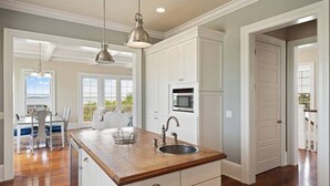 A kitchen with wooden countertops, white cabinetry, a built-in microwave, and pendant lighting. - ☀️Picturesque Views💥Game room👙Pool & Hot Tub (Brunswick)