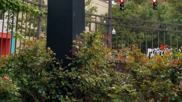 Un gran cartel de Downtown Inn con una vista clara del entorno urbano circundante, incluyendo un edificio de ladrillo identificado como 