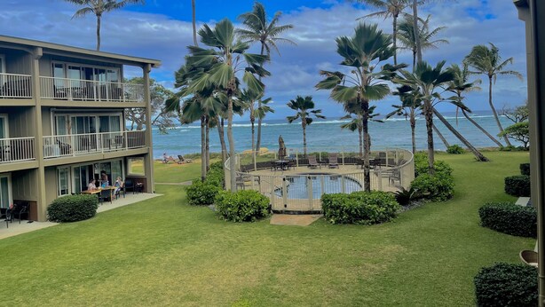 Ein Resort mit Poolbereich, Palmen und Meerblick.