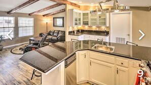 A modern kitchen with white cabinets, a black countertop, and a built-in dishwasher. - New!!! Amazing river and mountain deck view home!!!! (Parker)