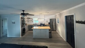 Una cocina moderna con una isla central, electrodomésticos integrados y un ventilador de techo.