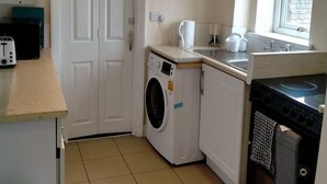Una cocina funcional con lavadora, estufa y ventana.