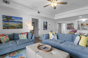 A living room with two sofas, a coffee table, and artwork on the walls.