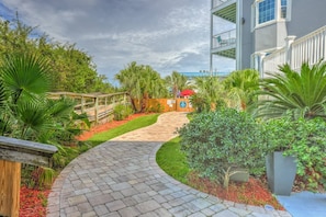Stroll along the winding pathway surrounded by lush greenery, leading to an entrance.
