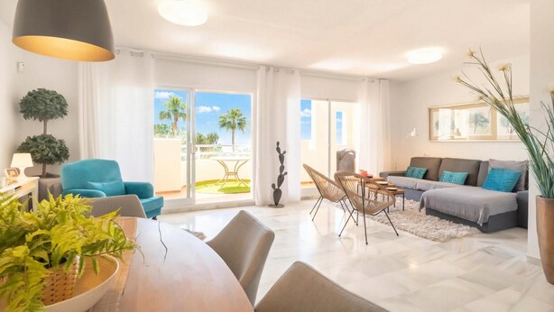 A spacious living area with a dining table, sofas, and a balcony with a view of palm trees. - Calahonda Elegance With Pool And Sea View, Mijas Costa, Spain (Mijas Costa)