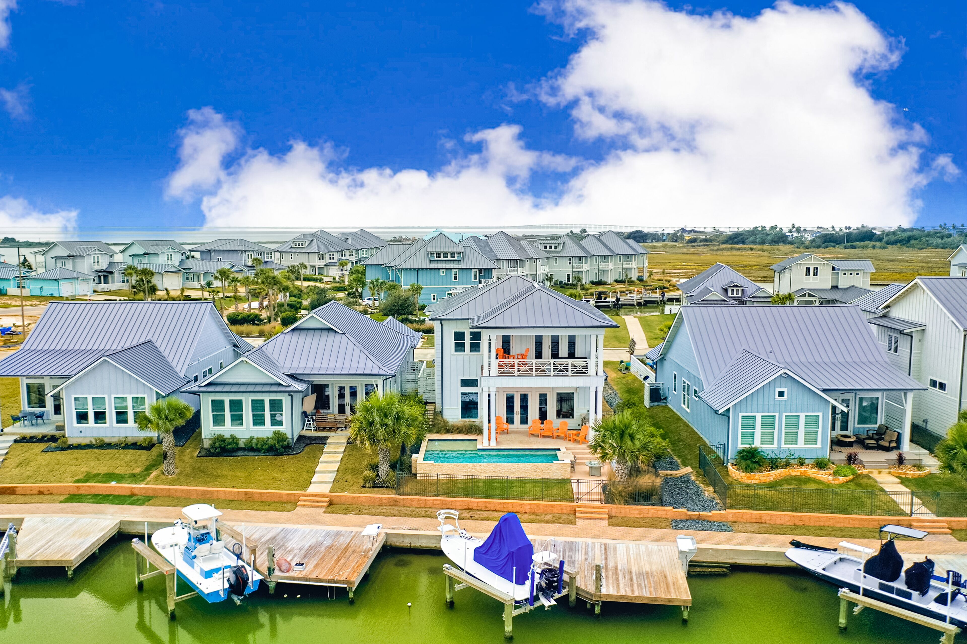 Modern, waterfront home with private pool, dock, balconies, central AC, and WiFi