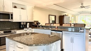 A modern kitchen with granite countertops, stainless steel appliances, and white cabinetry. - Luxurious Waterfront Stay w/ Large Sun Deck (Providenciales)