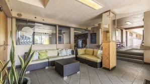 A modern lobby with a sofa, a coffee table, and a potted plant. - Direct Oceanfront Studio with 180 Degrees Ocean View in Maui Kaanapali Beach (Lahaina)
