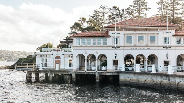 A waterfront building named Manly Pavilion with a white facade, multiple arches, and a red-tiled roof. - Bright & Peaceful Top-Floor Retreat with Harbour Views (Manly)
