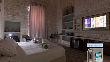 Ein Hotelzimmer mit Bett, Schreibtisch, Fernseher und einem Self-Check-in-Automaten.