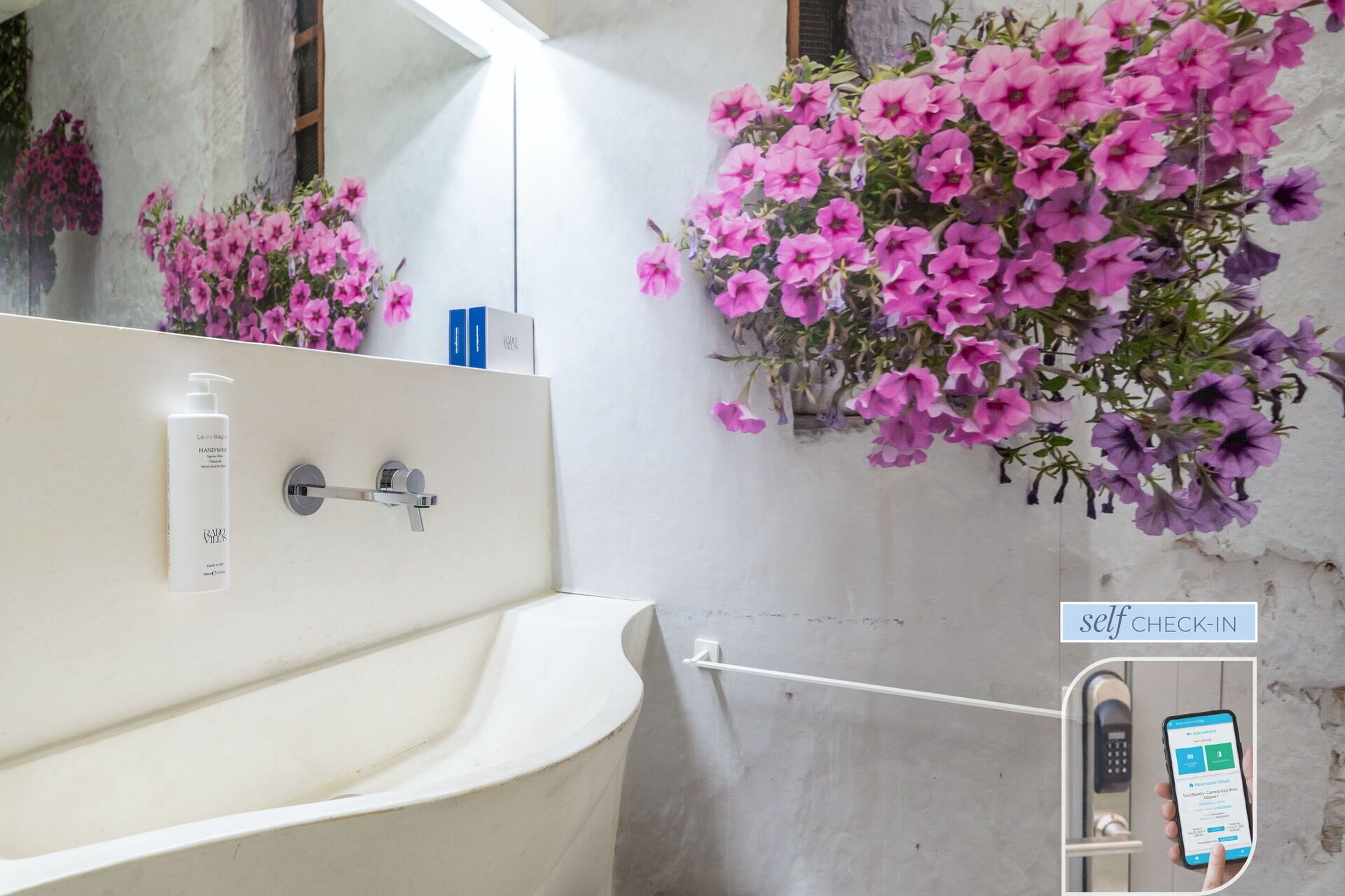 A bathroom with a white sink, a mirror, and a self-check-in kiosk.