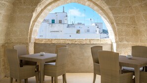 An outdoor seating area with wicker furniture and a stone archway. - Bed & Breakfast in Ostuni with 1 bedrooms sleeps 2 (Ostuni)