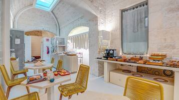 A rustic interior with stone walls, a kitchen area, and seating arrangements.