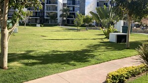 A well-maintained grassy courtyard with modern buildings in the background.