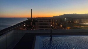 A rooftop pool with a view of the city skyline at dusk. - MALAGA BEACHFRONT PARADISE (Malaga)