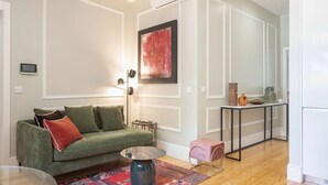 Ein modernes Wohnzimmer mit einem grünen Sofa, einem Couchtisch und einem roten Teppich.