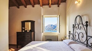 A bedroom with a bed, a dresser, a window with a mountain view, and a radiator.