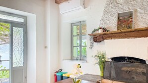 Une pièce avec une table en bois, une cheminée, une fenêtre et une porte.