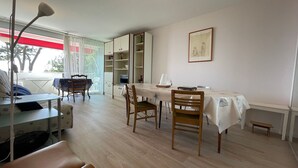 Ein Essbereich mit Tisch, Stühlen, einer Bank, einem Bücherregal und einem Fenster mit Blick.