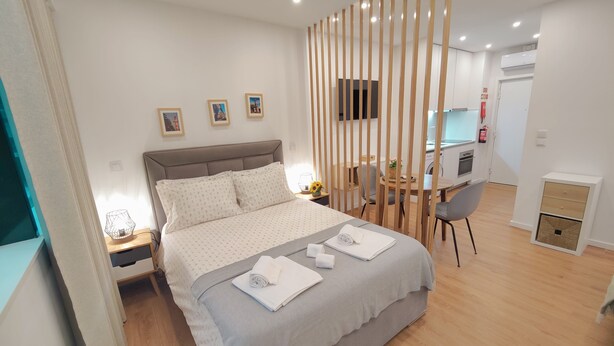Une chambre d’hôtel moderne équipée d’un lit, d’un bureau et d’une kitchenette.