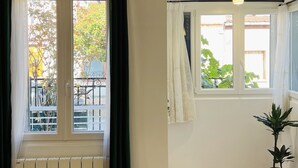 A room with a radiator, a window with a curtain, and a potted plant. - Appart PARIS Sud★ calm & bright - RER B 2 minutes (Cachan)