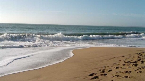 A beach with waves approaching the shore, a clear sky, and footprints in the sand. - Comfortable Cottage 4 Pers, Beach 200m, Private Parking (La Faute-sur-Mer)