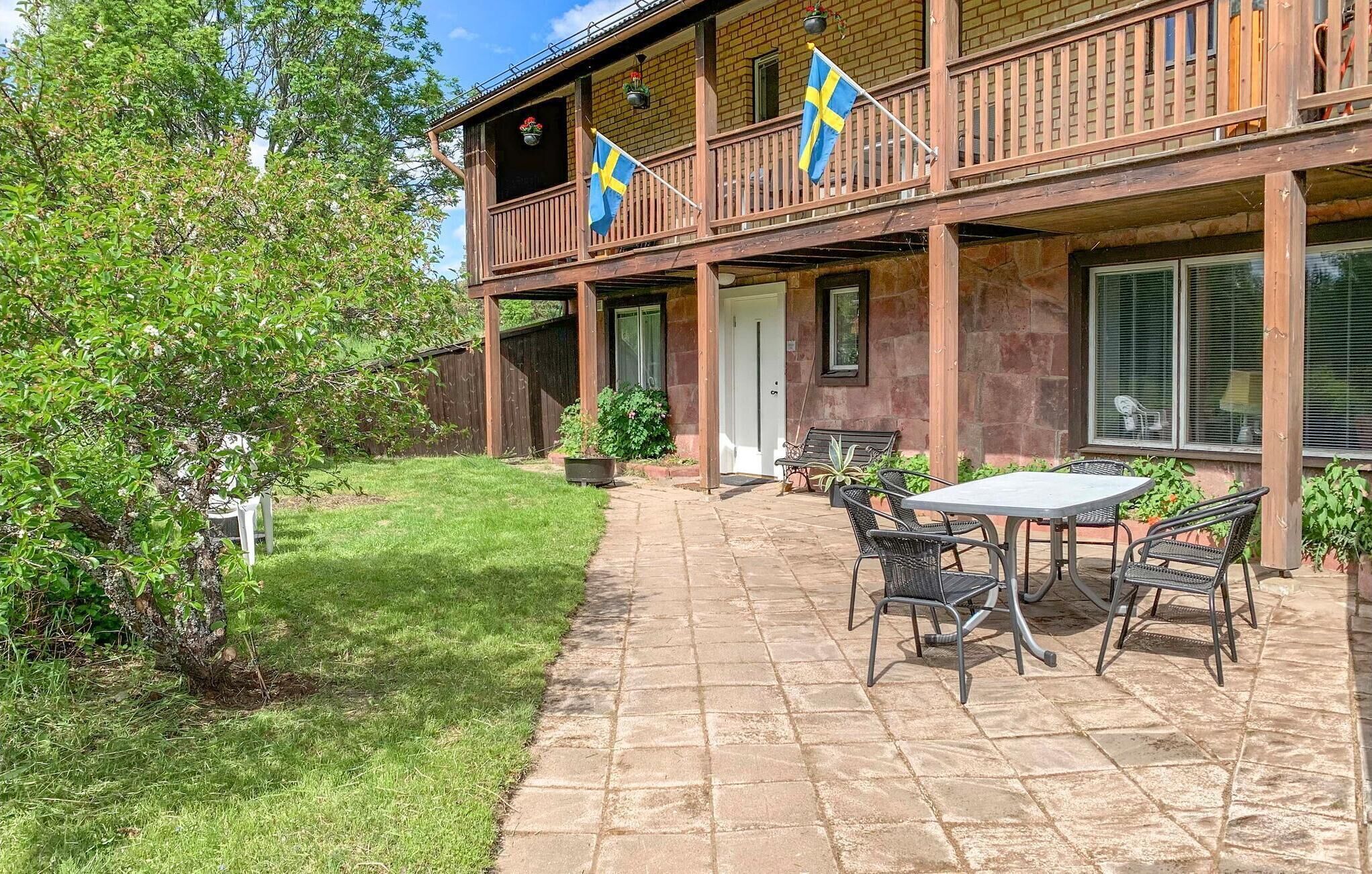 Un bâtiment en bois doté d’un balcon, de si èges en plein air et de drapeaux.