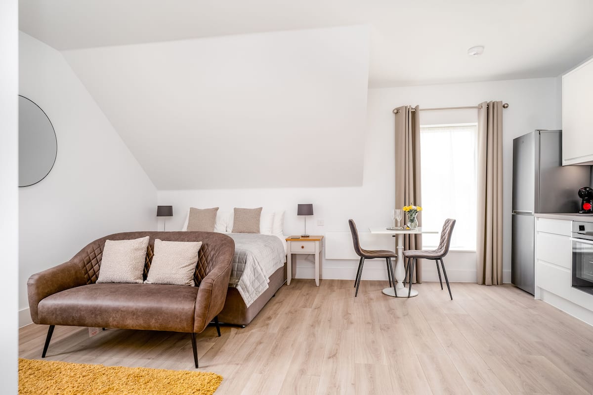 Une chambre moderne comprenant un lit, un canapé, un bureau et un coin repas.