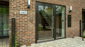 Ein Backsteinhaus mit einer großen Glasdoor, einer Treppe und einem Schild mit der Aufschrift "3 & 4 FINCH HOUSE".